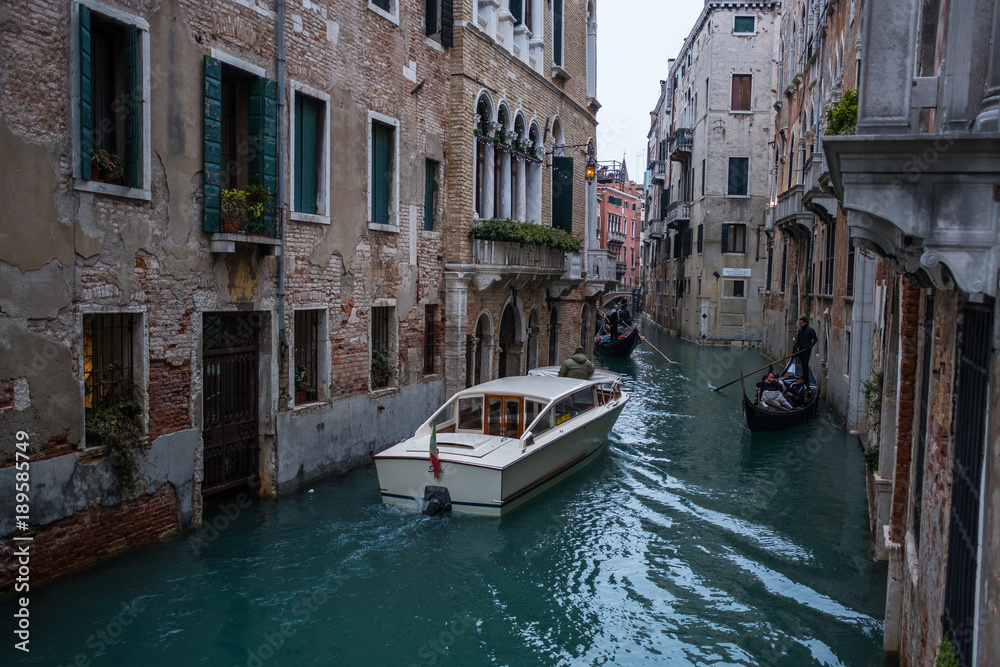 Venice channels with boats and the traditional Gondolas with no recognisable people.