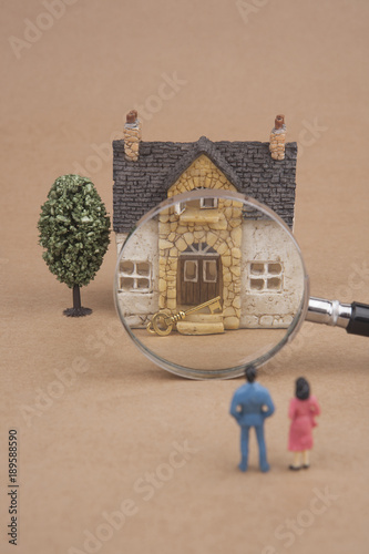miniature couple looking at new house 
