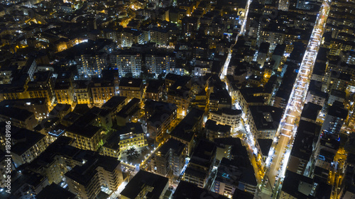 Aerial night view on the north part of the city of Naples, Italy. The streets are lit and surrounded by buildings and buildings.