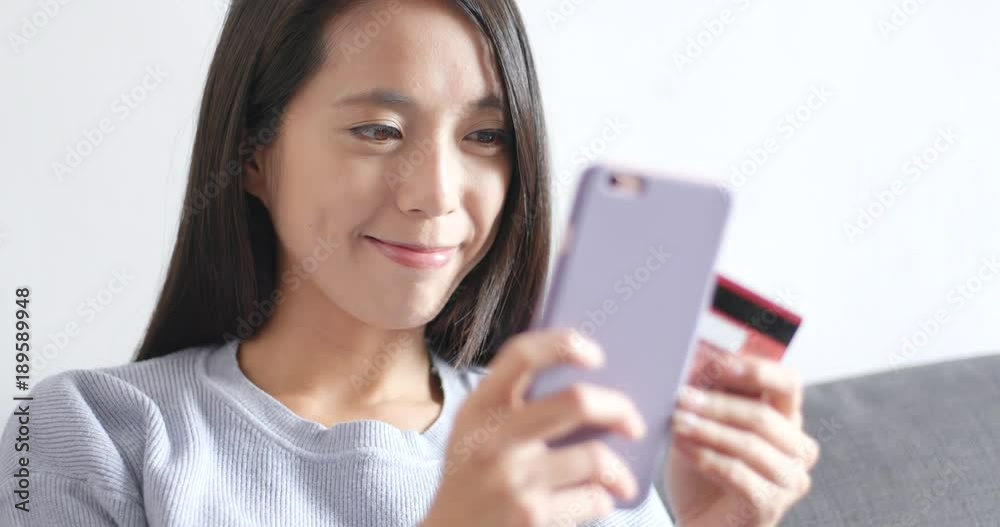 Woman shopping online on cellphone with credit card Woman shopping online on cellphone with credit card