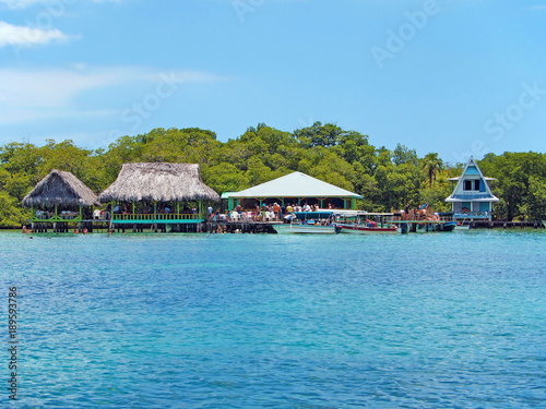Tropical restaurant overwater with boats and tourists, Caribbean sea, Cayo coral, Bocas del Toro, Panama, Central America