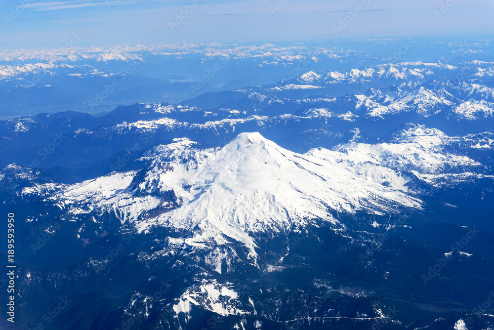 Snowcapped Mount Rainier and the Cascade Rangeas seen from an airplane window