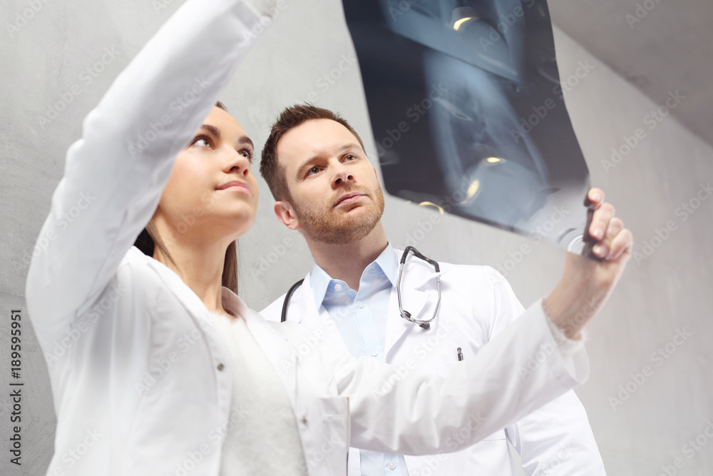 Pulmonolog, konsultacja medyczna . Lekarze oglądają zdjęcie rentgenowskie pacjenta. - obrazy, fototapety, plakaty 