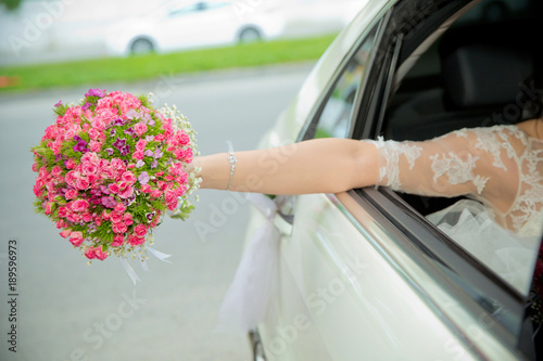 Photography The bride took out the pink flower bouquet out of the car