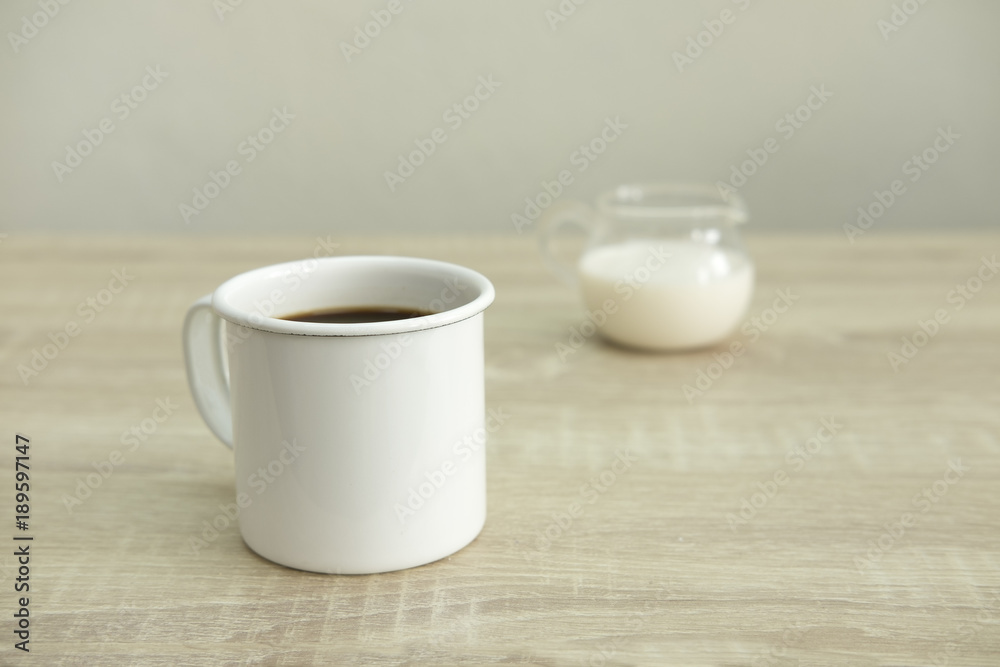 WHITE ENAMEL COFFEE MUG WITH MILK JAR
Enamel white coffee mug with milk jar on a wood table. WHITE ENAMEL COFFEE MUG WITH MILK JAR
Enamel white coffee mug with milk jar on a wood table.