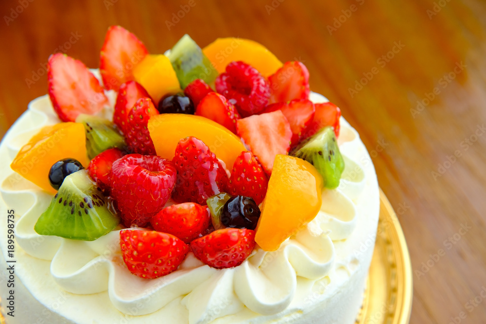 Cake with exotic fruits over wooden background