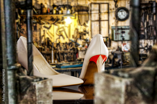 Handmade woman shoes and blurred background of workspace 
