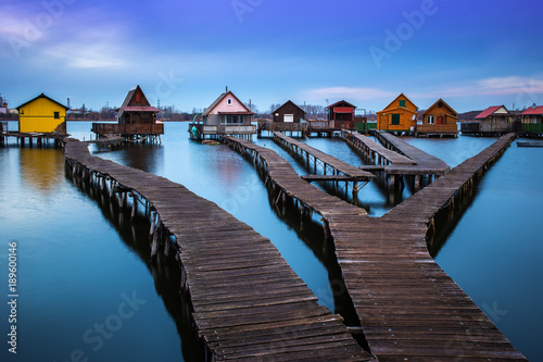 Bokod lake, Hungary - The famous floating village with piers and traditional fishing wooden cottages on a cloudy winter morning © zgphotography