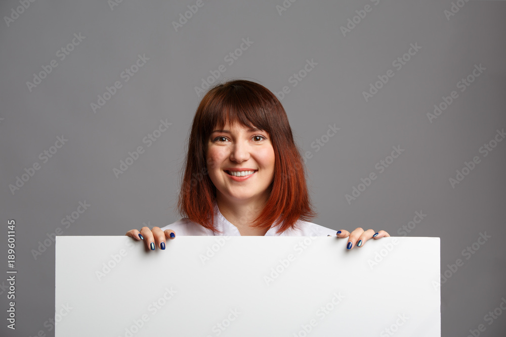 Photo of smiling woman cook in white coat with blank sheet for inscription Photo of smiling woman cook in white coat with blank sheet for inscription