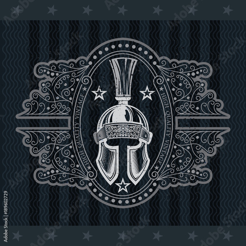 Spartan helmet front view in the center oval frame with pattern. Heraldic vintage label on blackboard