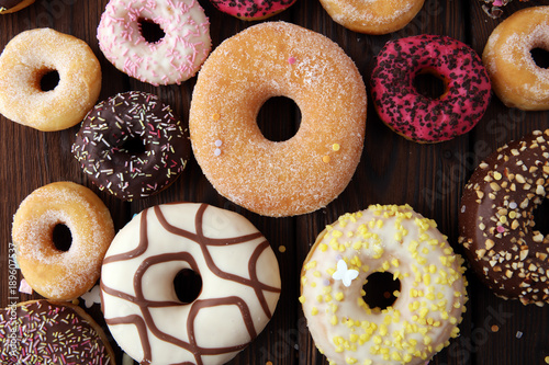 assorted donuts with chocolate frosted, pink glazed and sprinkles donuts.