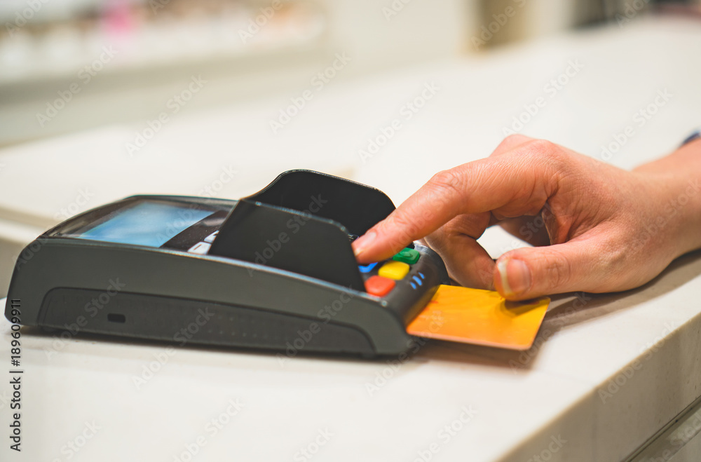 Woman makes payment via bank terminal in mall. Woman makes payment via bank terminal in mall.