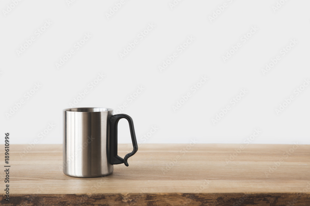 one silver cup on wooden table on white
