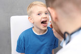 Chore gardło u dziecka. Pediatra sprawdza gardo chłopca