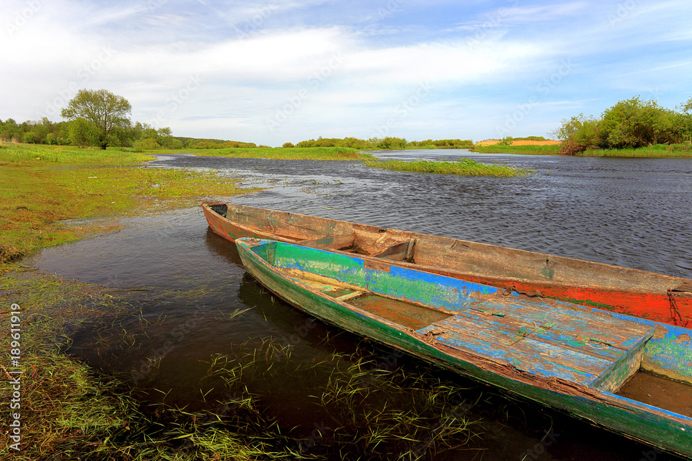 Obraz premium Panoramic view of wetlands and meadows with a vintage boat by the Biebrza river in Poland