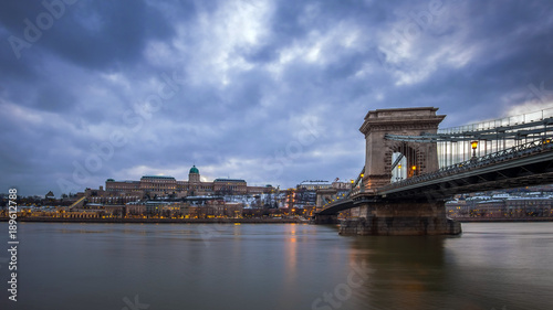 Budapest, Hungary - The famous Szechenyi Chain Bridge over River Danube with Buda Castle Royal Palace at dusk