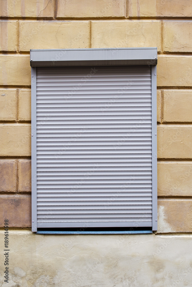 window with blinds on the brick wall