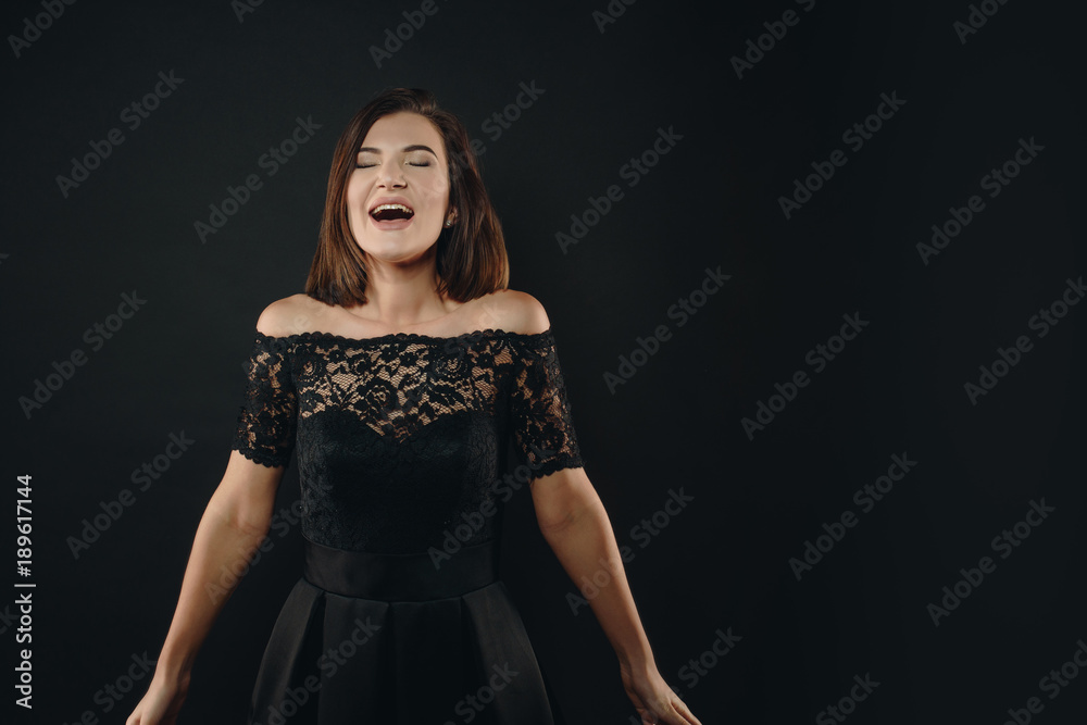 Extraordinary joy. The girl in the black dress rejoices and expresses her emotions. She is dressed in a black dress. Epic moment. Lust. Extraordinary joy. The girl in the black dress rejoices and expresses her emotions. She is dressed in a black dress. Epic moment. Lust.