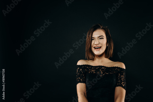 Extraordinary joy. The girl in the black dress rejoices and expresses her emotions. She is dressed in a black dress. Epic moment. Lust.