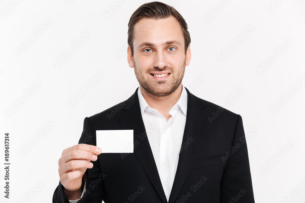 Smiling young businessman holding empty business card. Smiling young businessman holding empty business card.