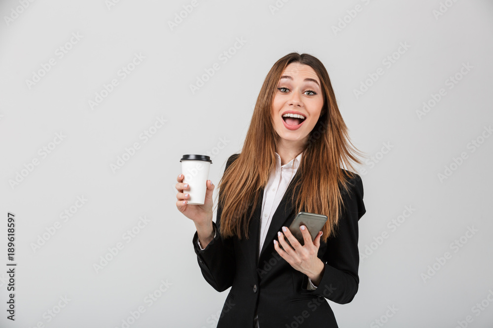 Happy woman looking camera while holding cup of coffee and smartphone isolated Happy woman looking camera while holding cup of coffee and smartphone isolated