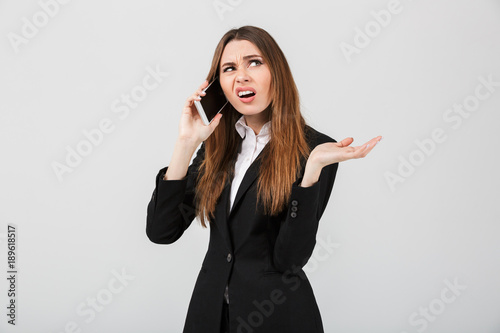 Angry displeased lady talking on smartphone isolated