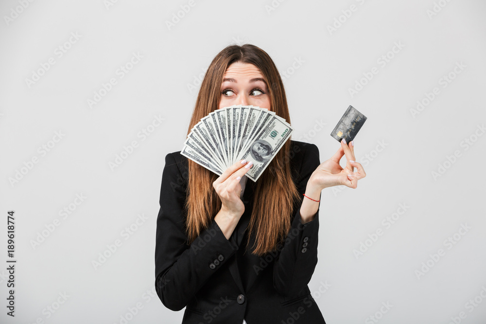 Pretty lady hiding behind money and holding credit card isolated Pretty lady hiding behind money and holding credit card isolated
