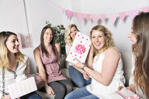 Best Friends on baby shower party celebrating giving kid stuff as present