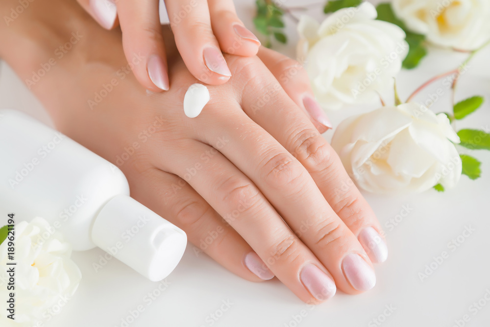Beautiful groomed woman's hands applying moisturizing cream. Cares about clean, beautiful and soft hands skin. Manicure and pedicure beauty salon. Healthcare concept.