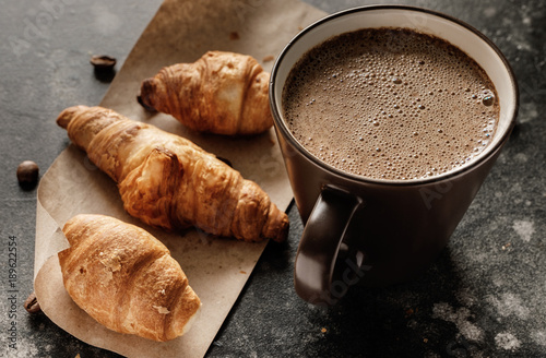 Morning coffee in a cup on a table with croissants photo