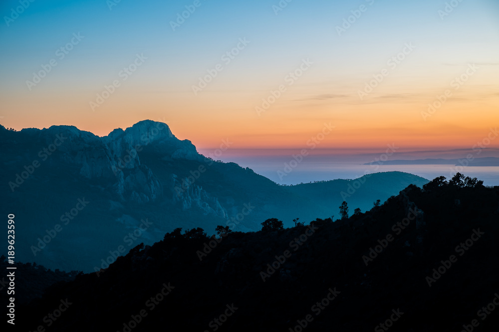 Bergkulisse vor Sonnenuntergang mit Weitblick auf das Meer Bergkulisse vor Sonnenuntergang mit Weitblick auf das Meer