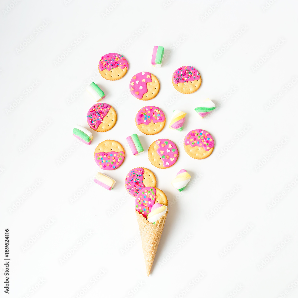 Gingerbread cookies with pink glaze and marshmallow in waffle cone on withe background. Flat lay. top view.