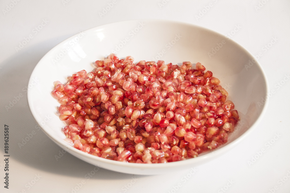 Close up Pomegranate Seeds in Plate, isolated Close up Pomegranate Seeds in Plate, isolated