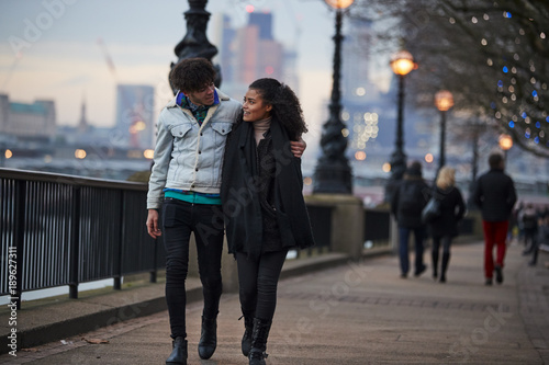 Couple Walking Along South Bank On Winter Visit To London photo