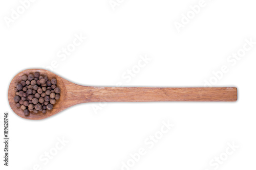 Whole allspice, jamaica pepper  on wooden spoon isolated on white background