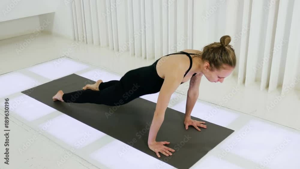 yoga girl bends back up lying on the floor in the studio yoga girl bends back up lying on the floor in the studio