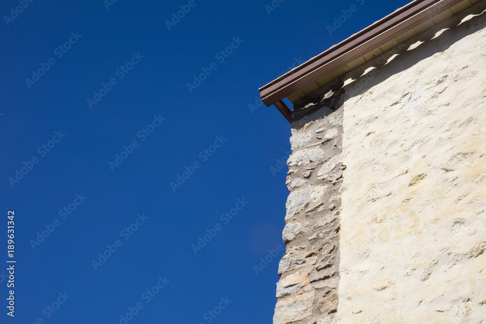 Detail of mediterranean country house made of stone on a sunny day in blue background in Catalonia