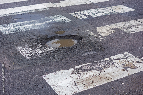 Large pothole on the road, on pedestrian crossing