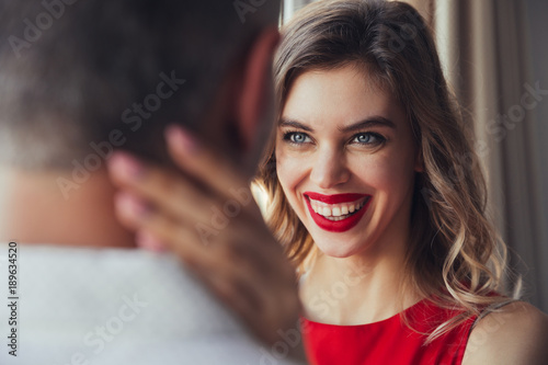 Portrait of laughing woman hug her husband at home