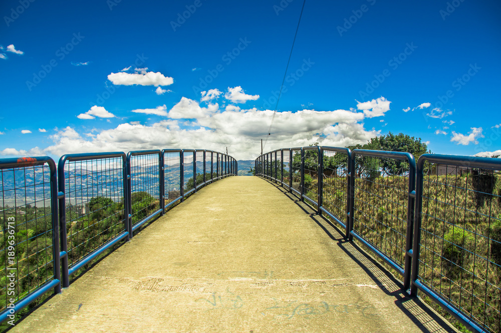 Outdoor view of pedestrian bridge over a road to visit the municipal dump in a beautiful day in the city of Quito, Ecuador