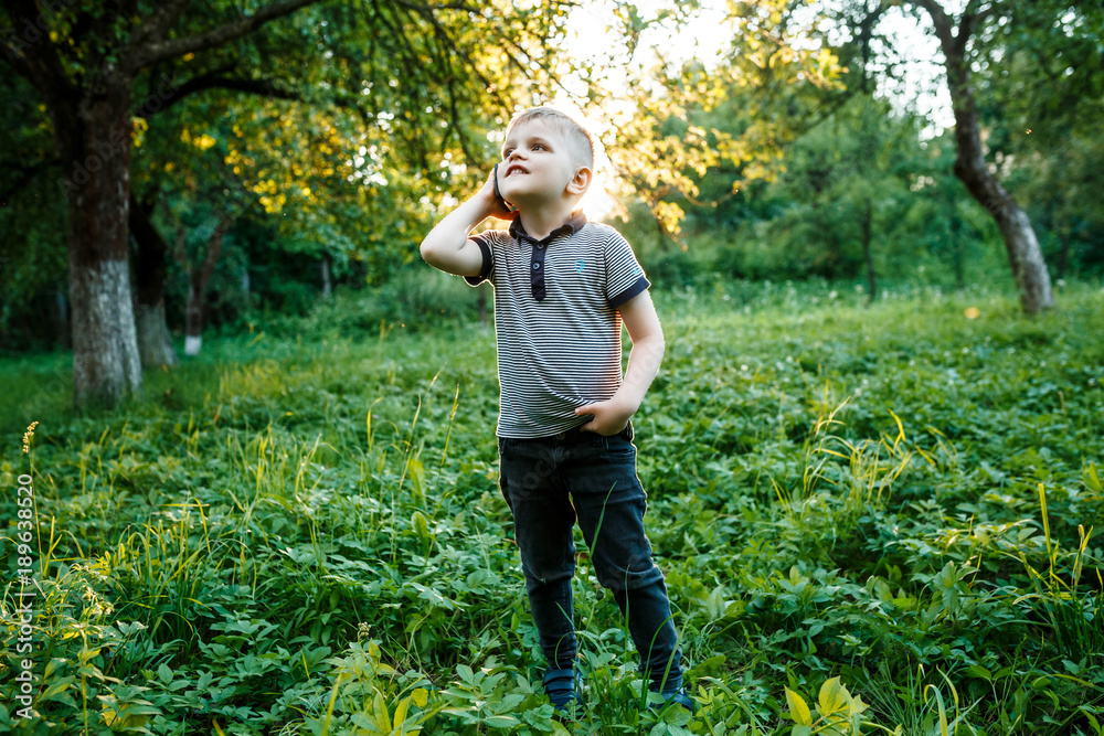 Little boy with the phone in his hands outdoors. Little boy with the phone in his hands outdoors.