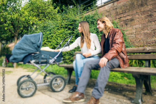 Young Parents With Baby Stroller In The Park