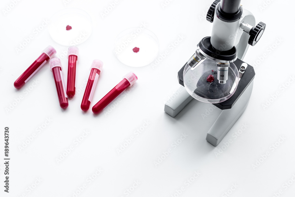 Blood analysis in clinacal lab. Test tubes near microscope on white background top view copy space Blood analysis in clinacal lab. Test tubes near microscope on white background top view copy space