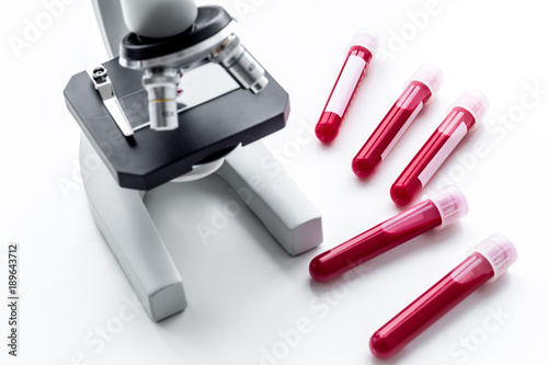 Blood test concept. Blood samples near microscope on white background top view close up