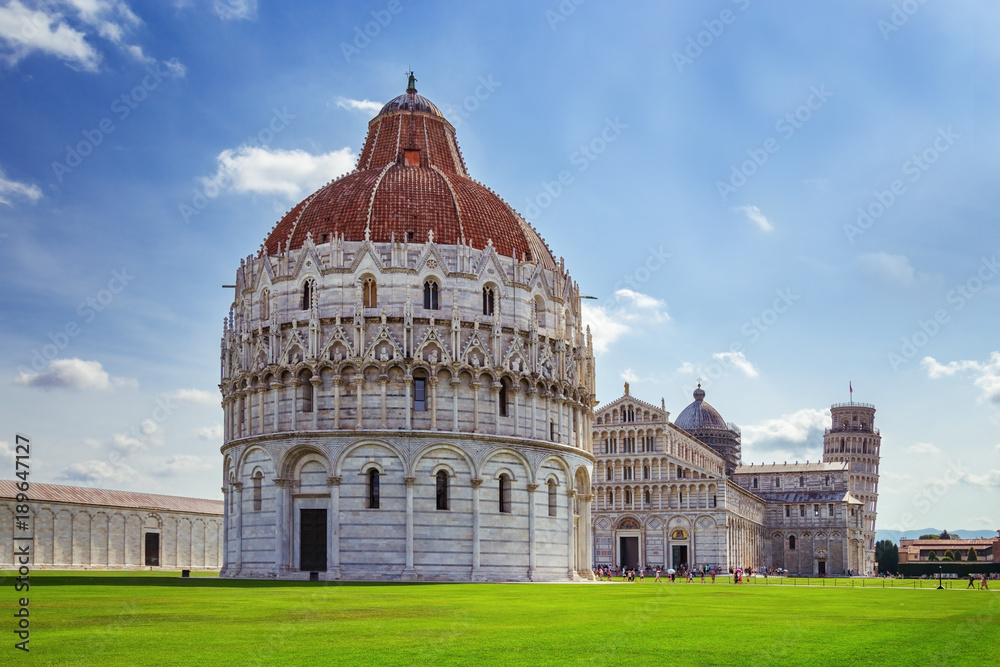 The Pisa Baptistery with the Cathedral and Leaning Tower of Pisa. Italy, June 2017. Famous Italian architecture.