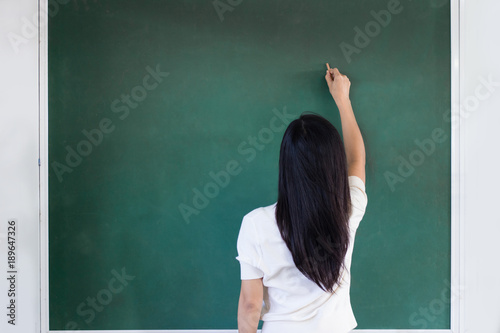 Woman writting on green board © toonzzz