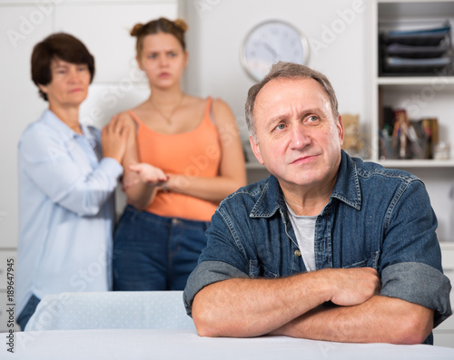 Upset father is sitting at the table and her family is sympathying with her © JackF