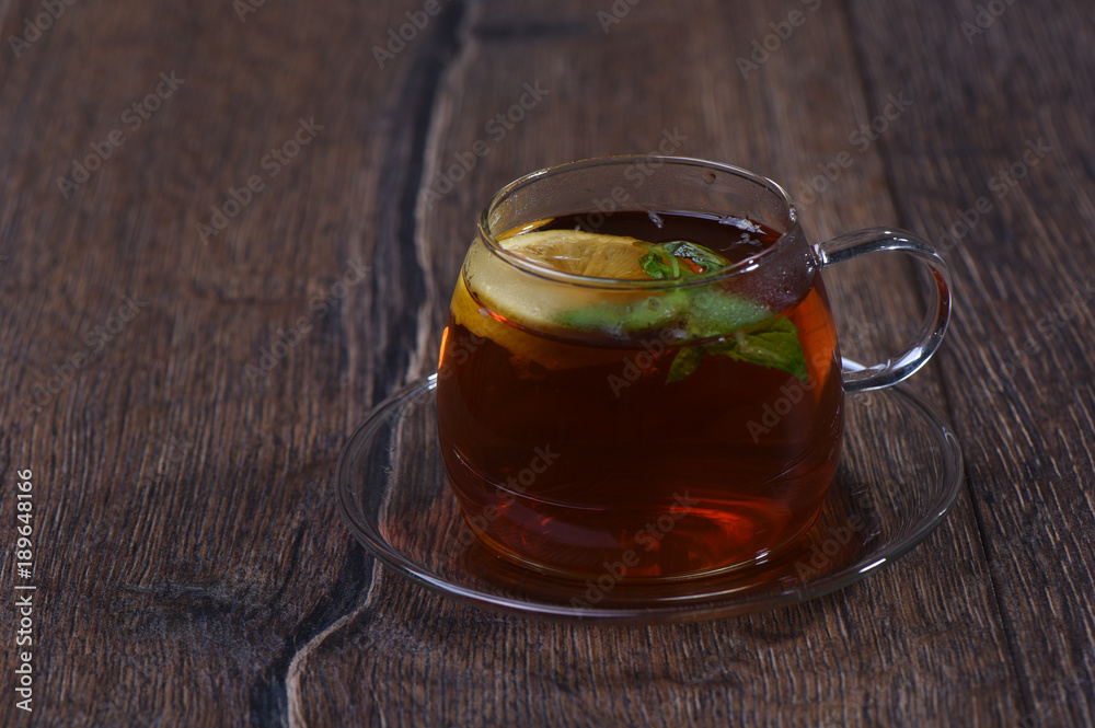 Fototapeta premium Glass cup with lemon and mint tea