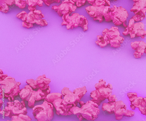 Pink popcorn on purple paper background. Fashion pop art style. Top view.