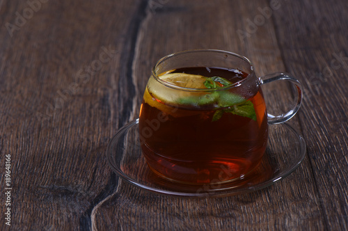 Glass cup with lemon and mint tea